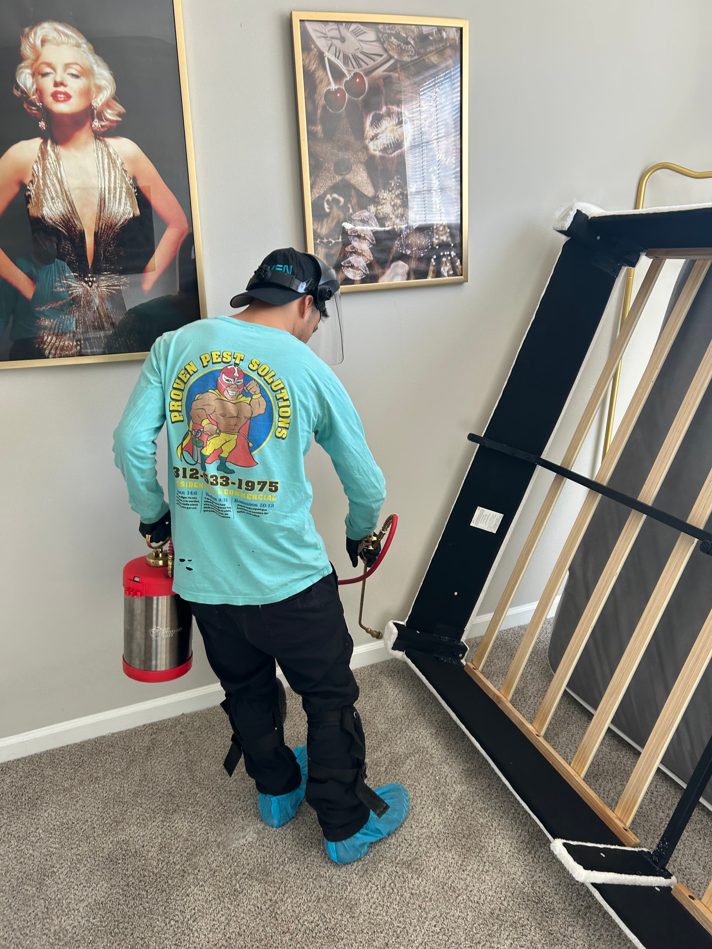 A pest technician treating a bedroom for bed bugs